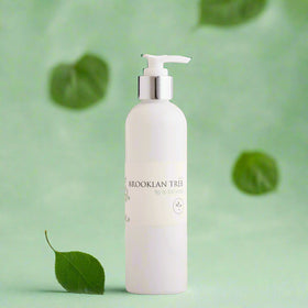 bottle only with natural looking green leaves on a very pale light green background 