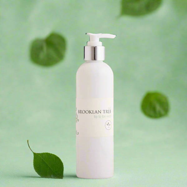 bottle only with natural looking green leaves on a very pale light green background 